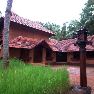 Photograph showing exterior view of Residence for Dr.Achutshankar with mangalore tiled roof & rammed earth walls.
