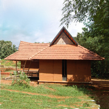 Photograph showing exterior view of Office for Bhoomija Creations with mangalore tiled roof & rammed earth walls.